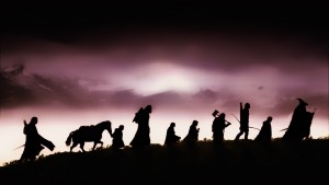The cast of The Fellowship of the Rings, silhouetted against a cloudy, purple sky.